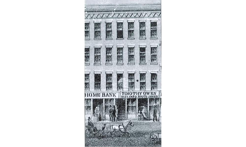 Black and white lithograph portraying a three story building with stores on the first floor and horses pulling wagons in the road