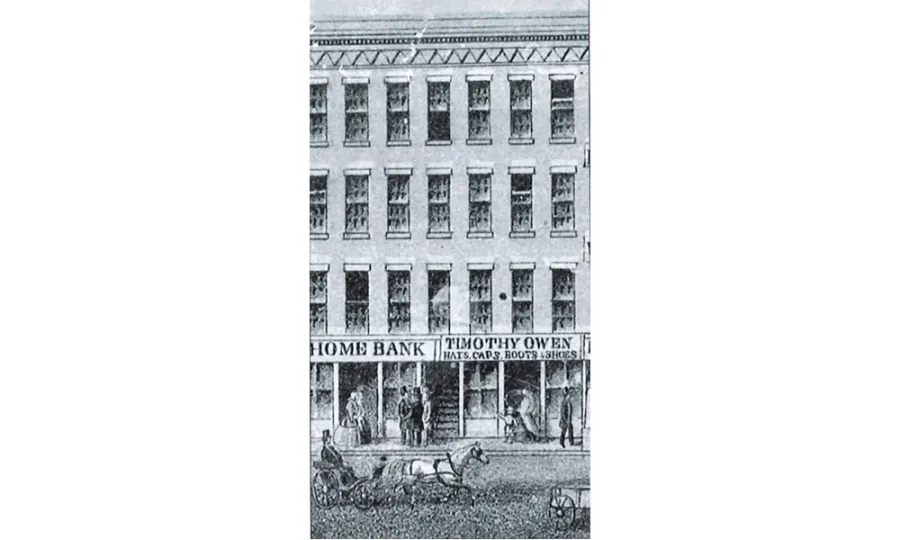 Black and white lithograph portraying a three story building with stores on the first floor and horses pulling wagons in the road
