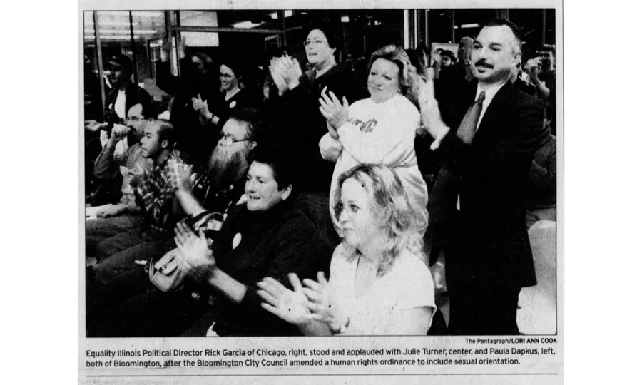 Newspaper clipping of a group of men and women clapping.