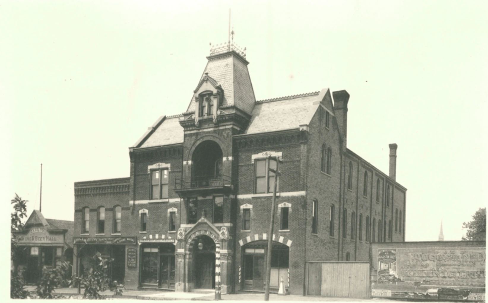 Sepia photo of a three-story brick building.