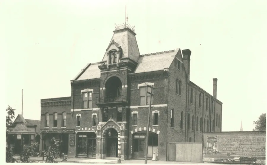 Sepia photo of a three-story brick building.