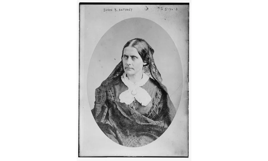 Portrait of a stern-faced woman in lace blouse with parted hair.
