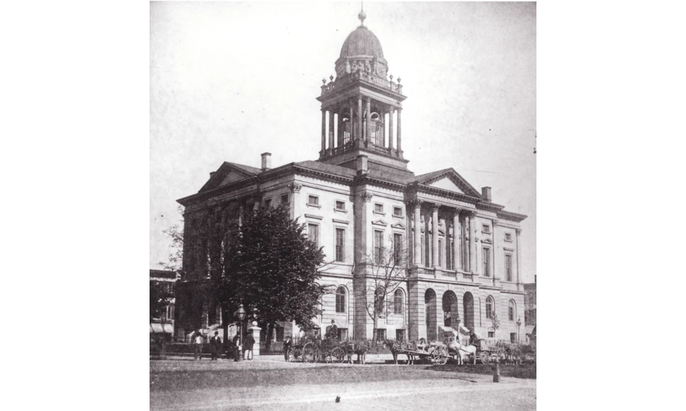 Black and white photo of a three-story stone courthouse with square rotunda.