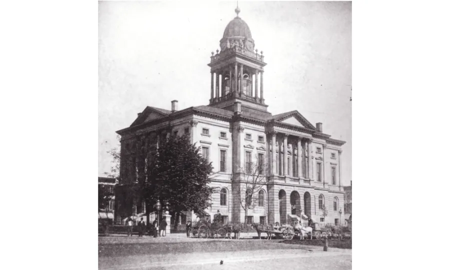 Black and white photo of a three-story stone courthouse with square rotunda.
