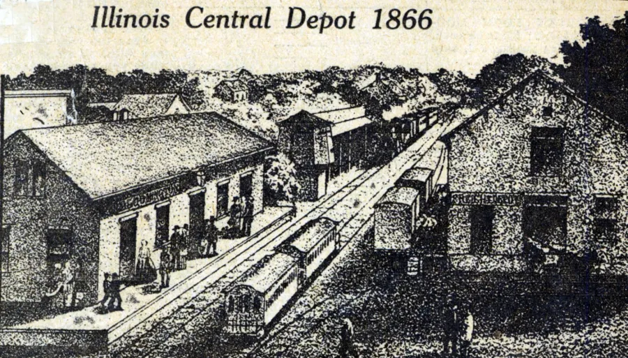 Illinois Central Depot in 1866, showing a Victorian-era railroad station with multiple tracks, passenger cars, platform structures, and surrounding buildings nestled among trees.